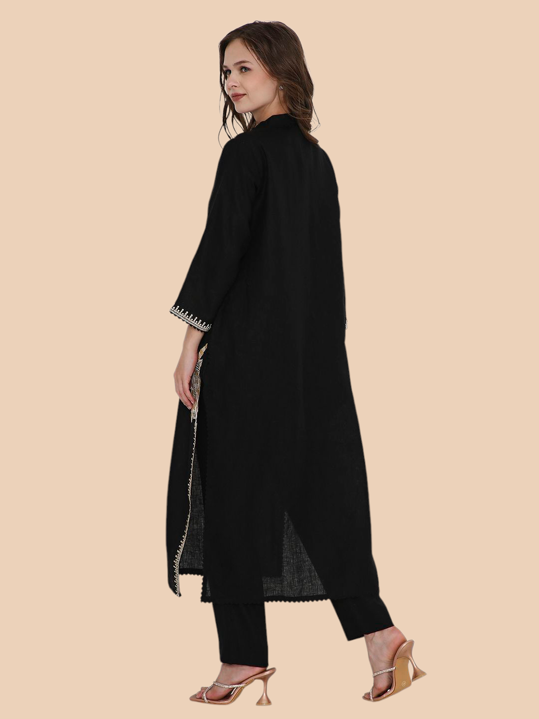 Woman wearing a black outfit with a beige background