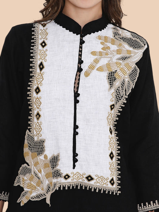 Black and white embroidered garment with gold details on a beige background