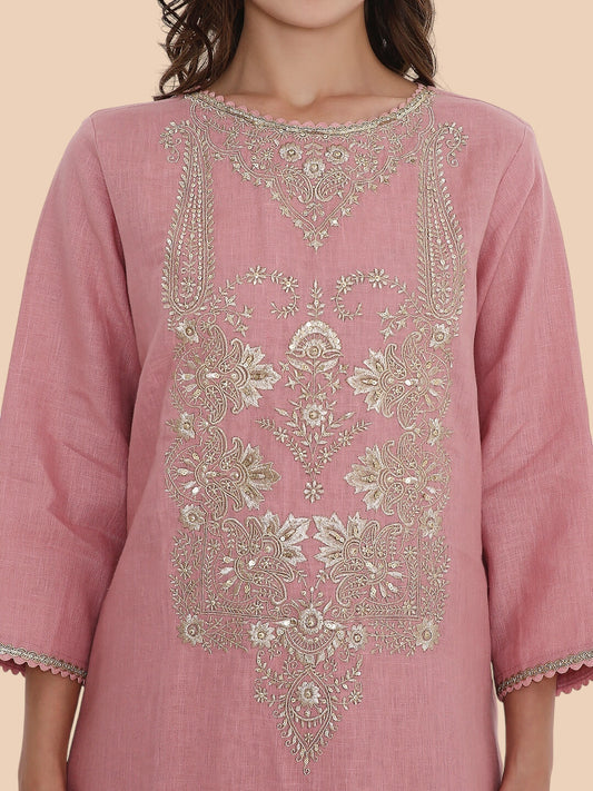 Pink embroidered kurta worn by a person on a beige background