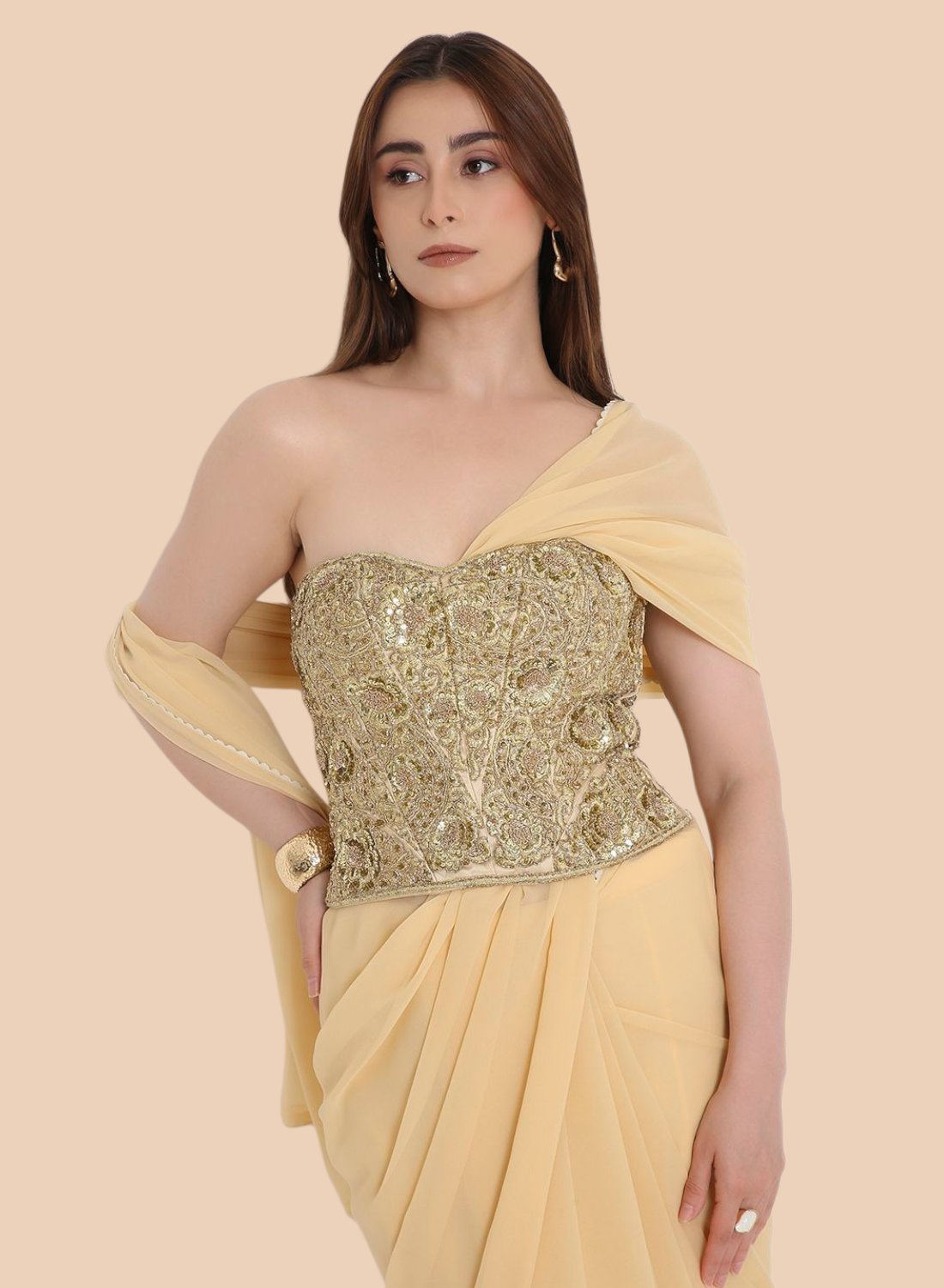 Woman wearing a yellow corset with a gold blouse on a beige background