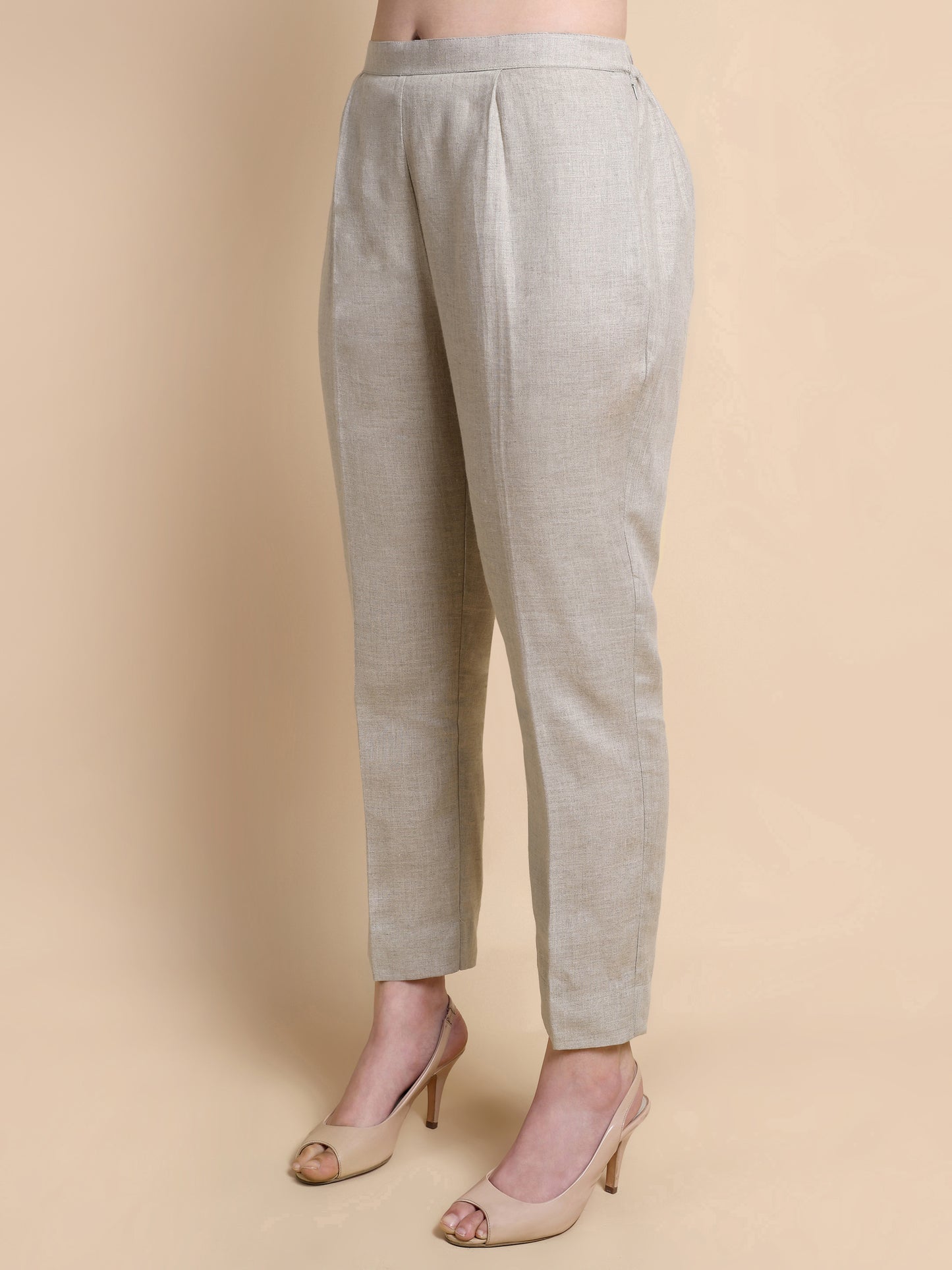 Light gray pants worn by a person on a beige background