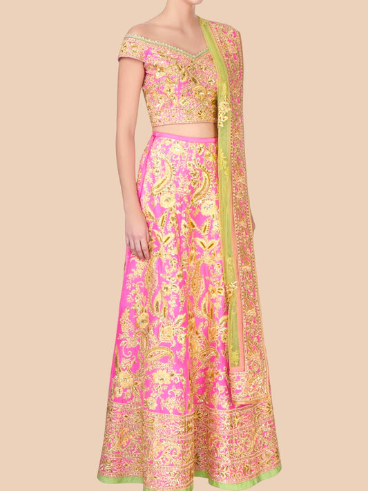 Traditional pink and gold embroidered outfit on a beige background