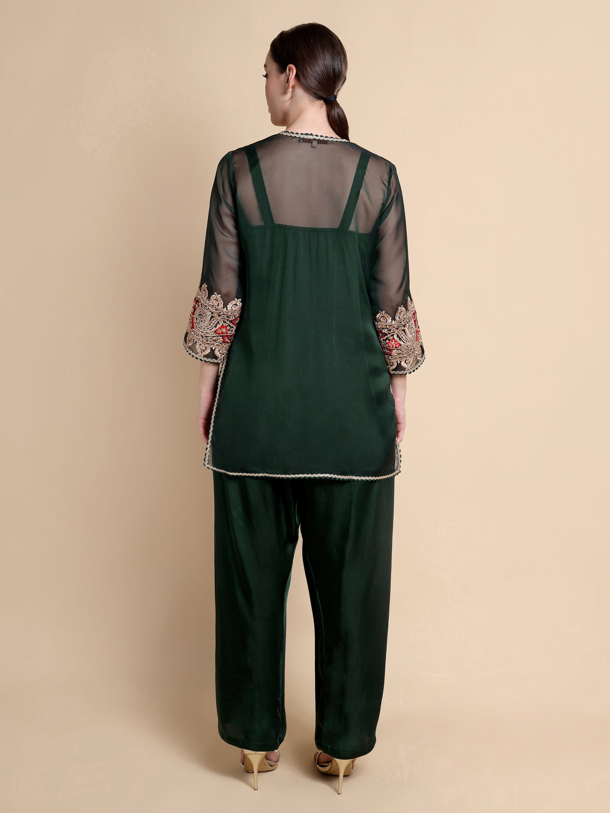 Green outfit with floral embroidery on a beige background