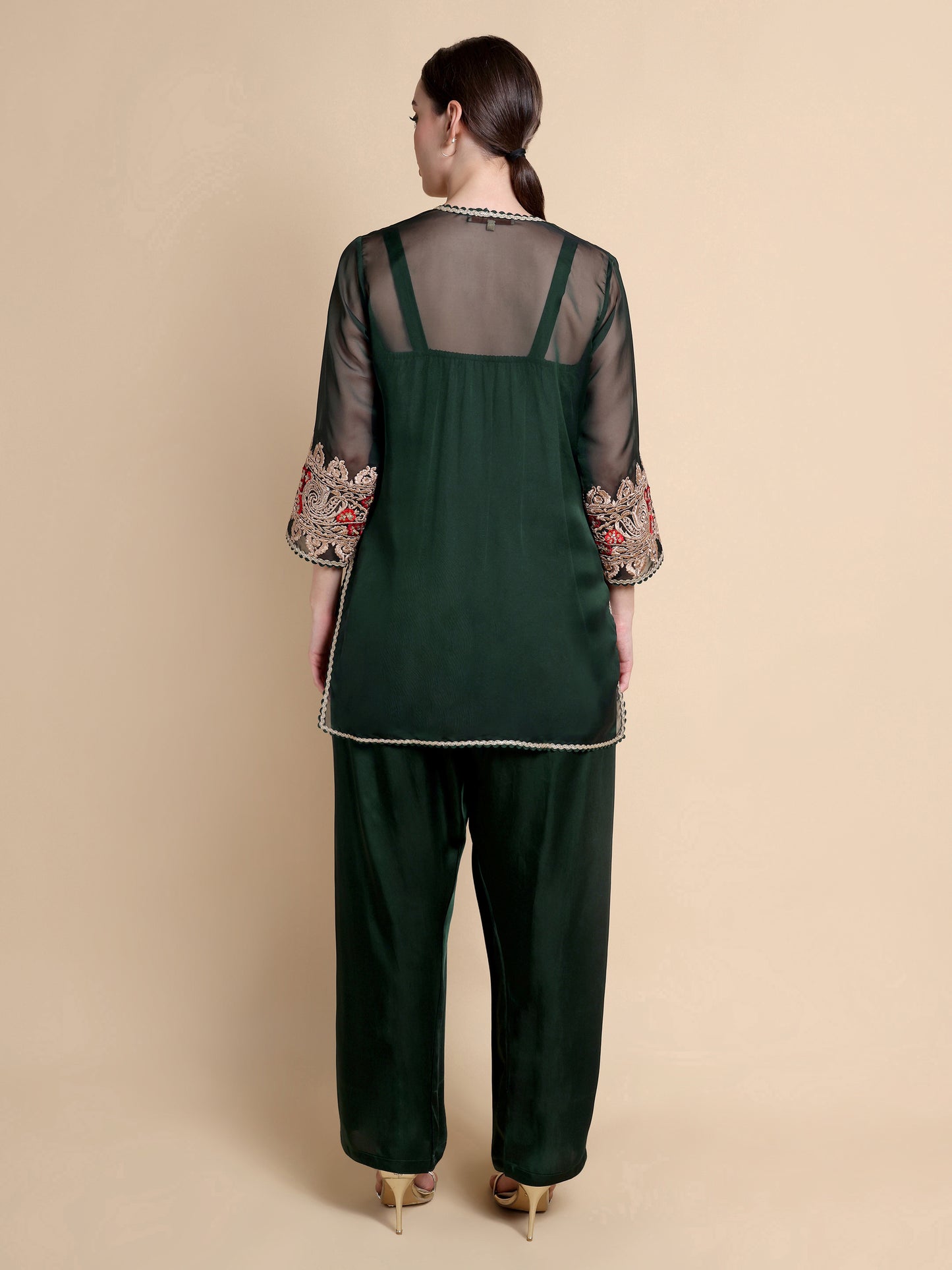 Green outfit with floral embroidery on a beige background