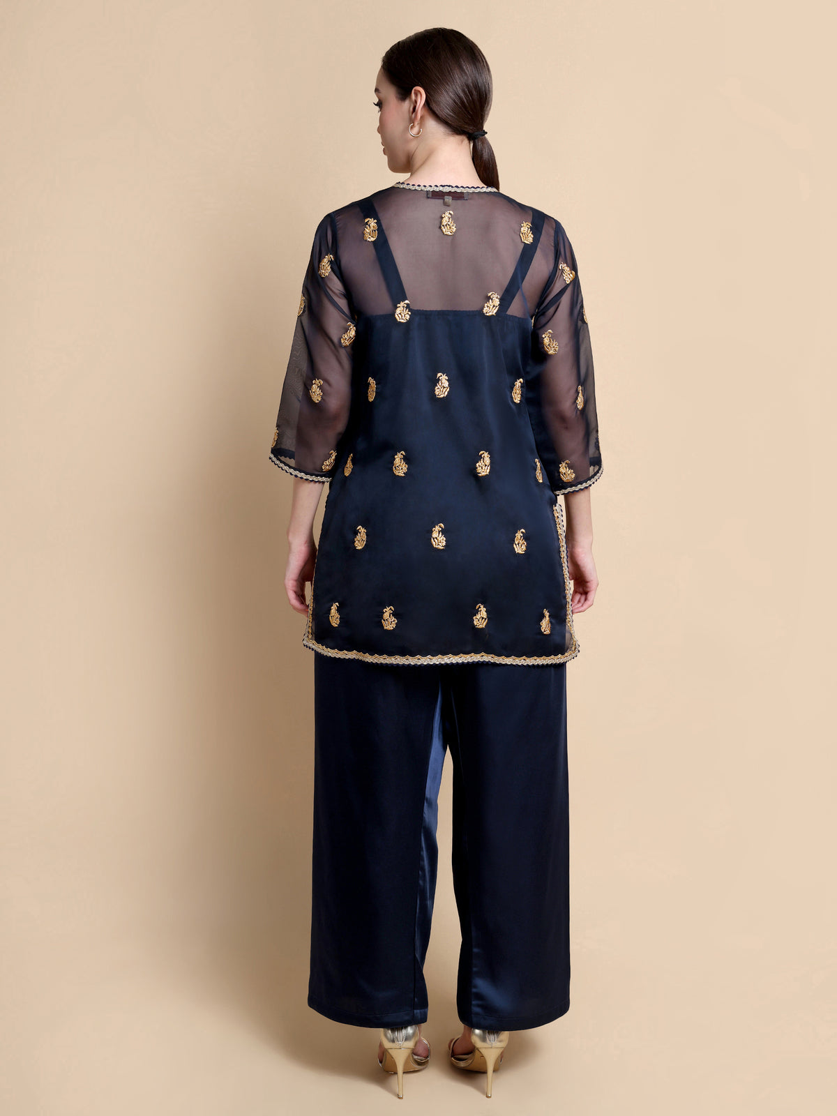 Navy blue outfit with gold detailing on a beige background