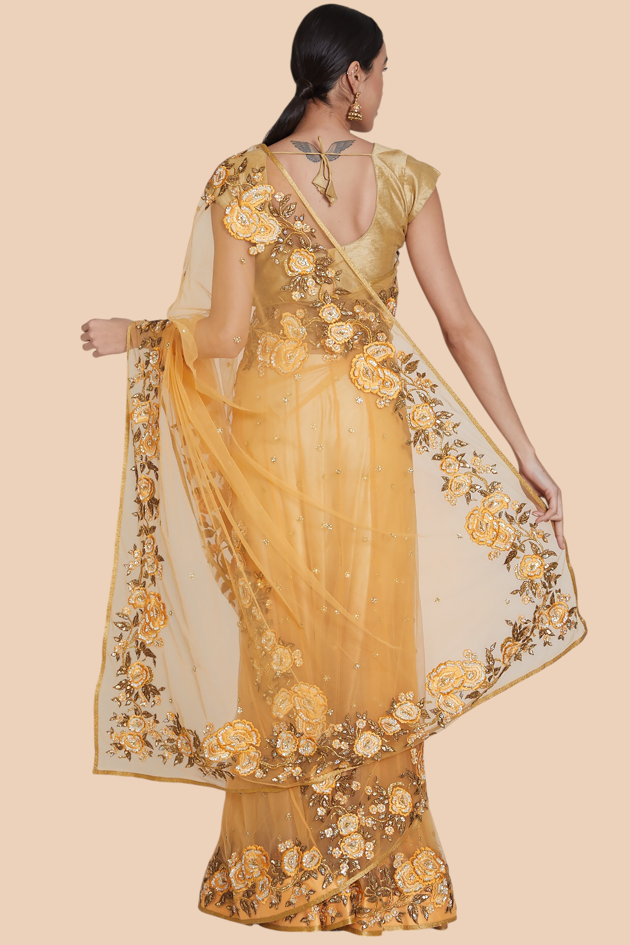 Back view showing embroidery and wraparound silhouette of yellow sari