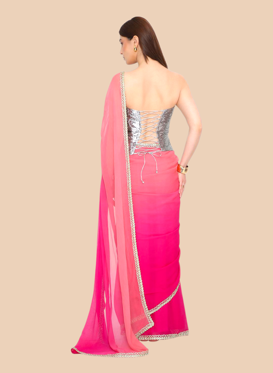 Woman wearing a pink corset with a silver blouse on a beige background