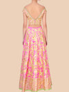 Pink and gold embroidered traditional outfit on a beige background