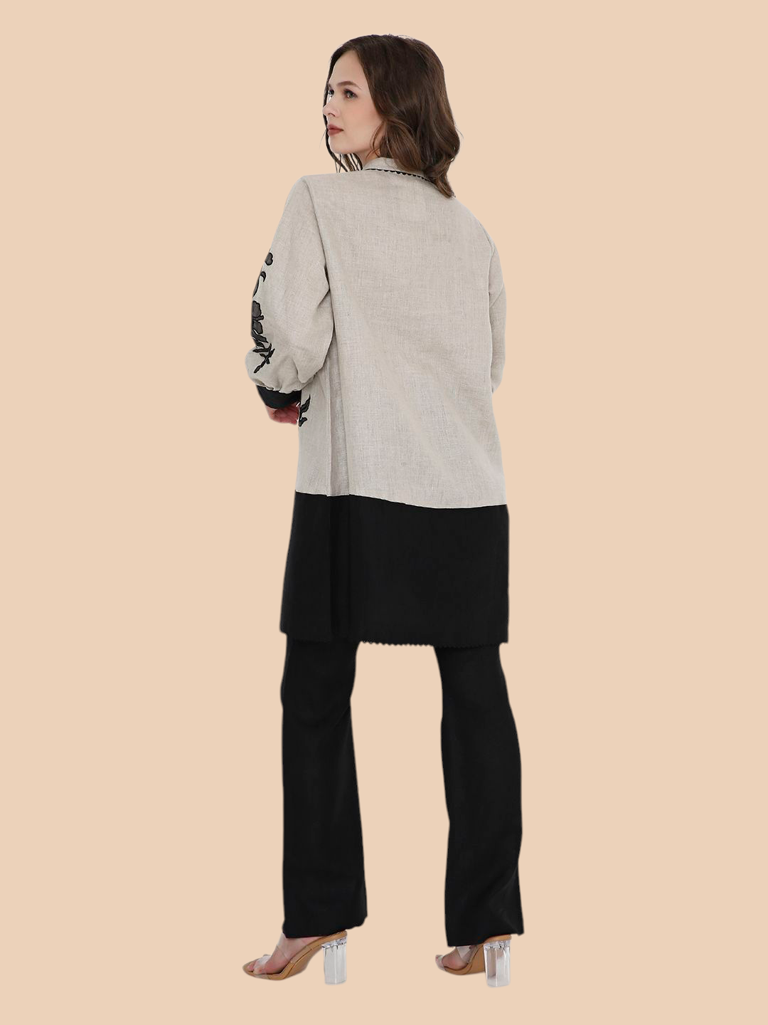 Woman wearing a gray top and black pants on a beige background