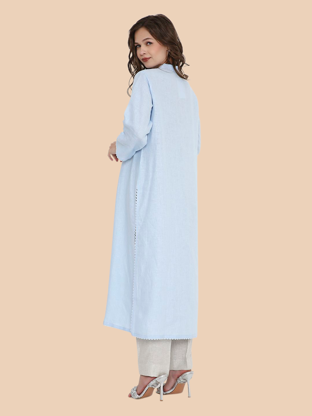 Woman wearing a light blue long coat on a beige background