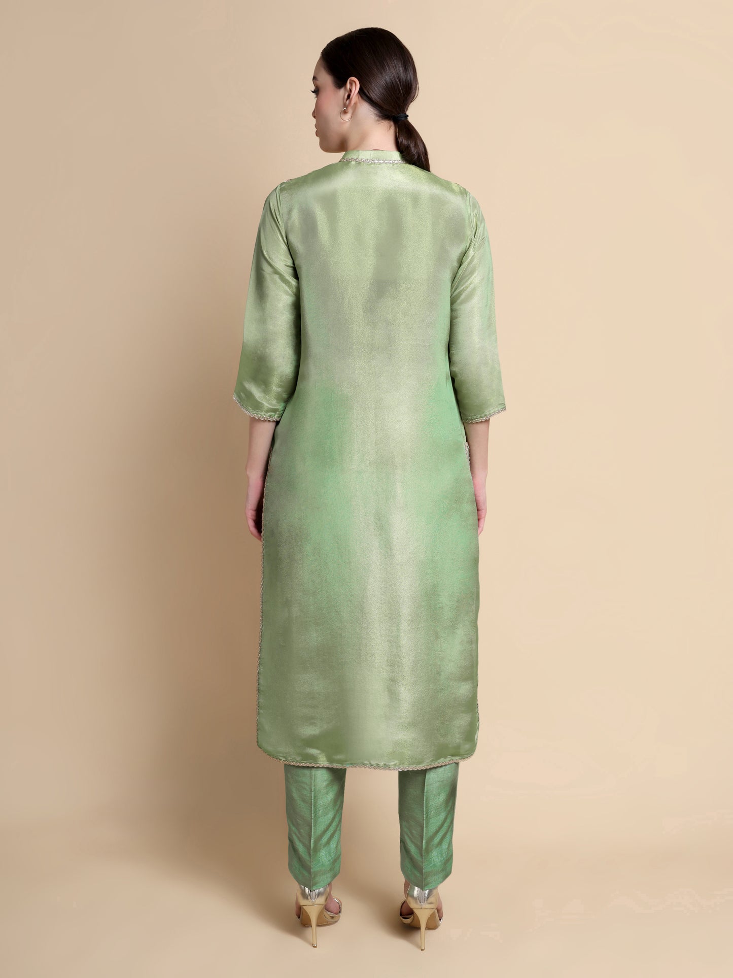 Woman wearing a green kurta with a plain background