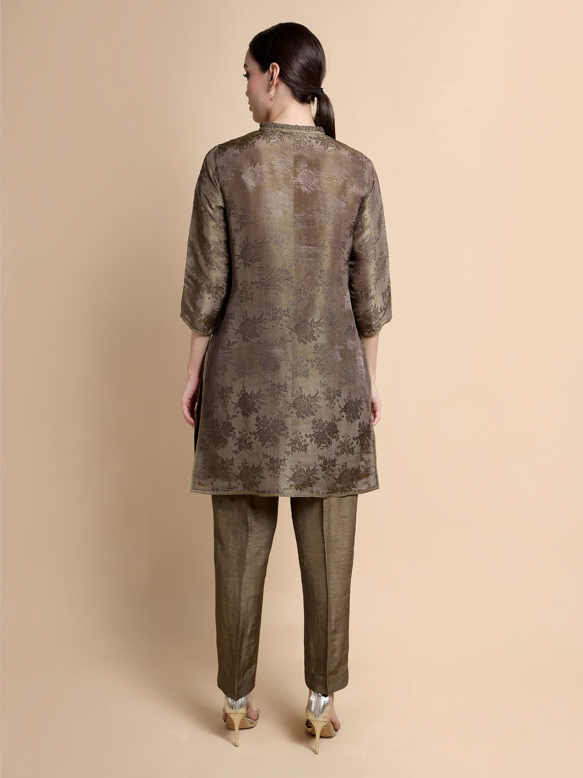 Woman wearing a patterned kurta with pants on a beige background