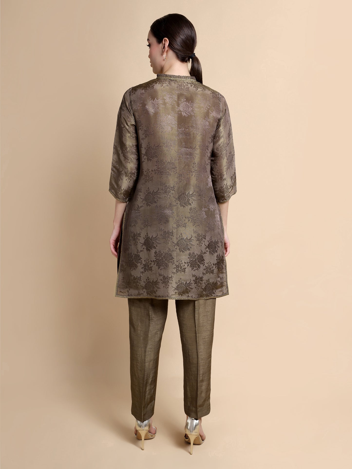 Woman wearing a patterned kurta with pants on a beige background