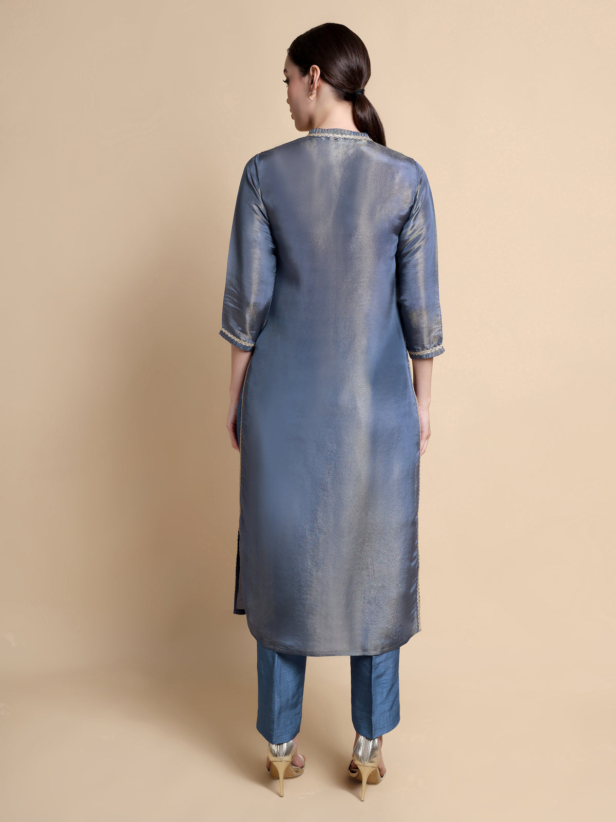 Woman wearing a blue kurta with a plain background