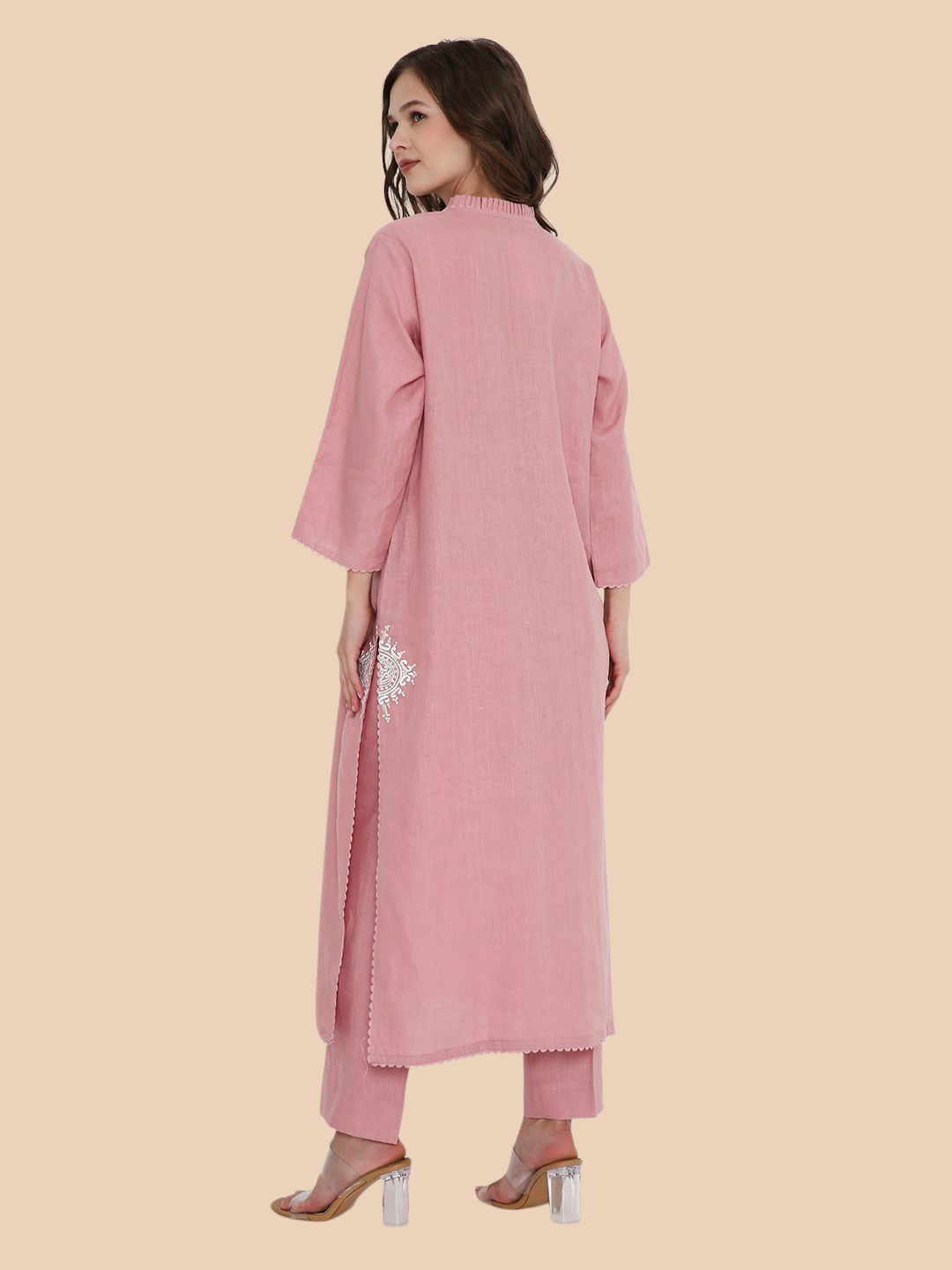 Woman wearing a pink traditional outfit with a beige background