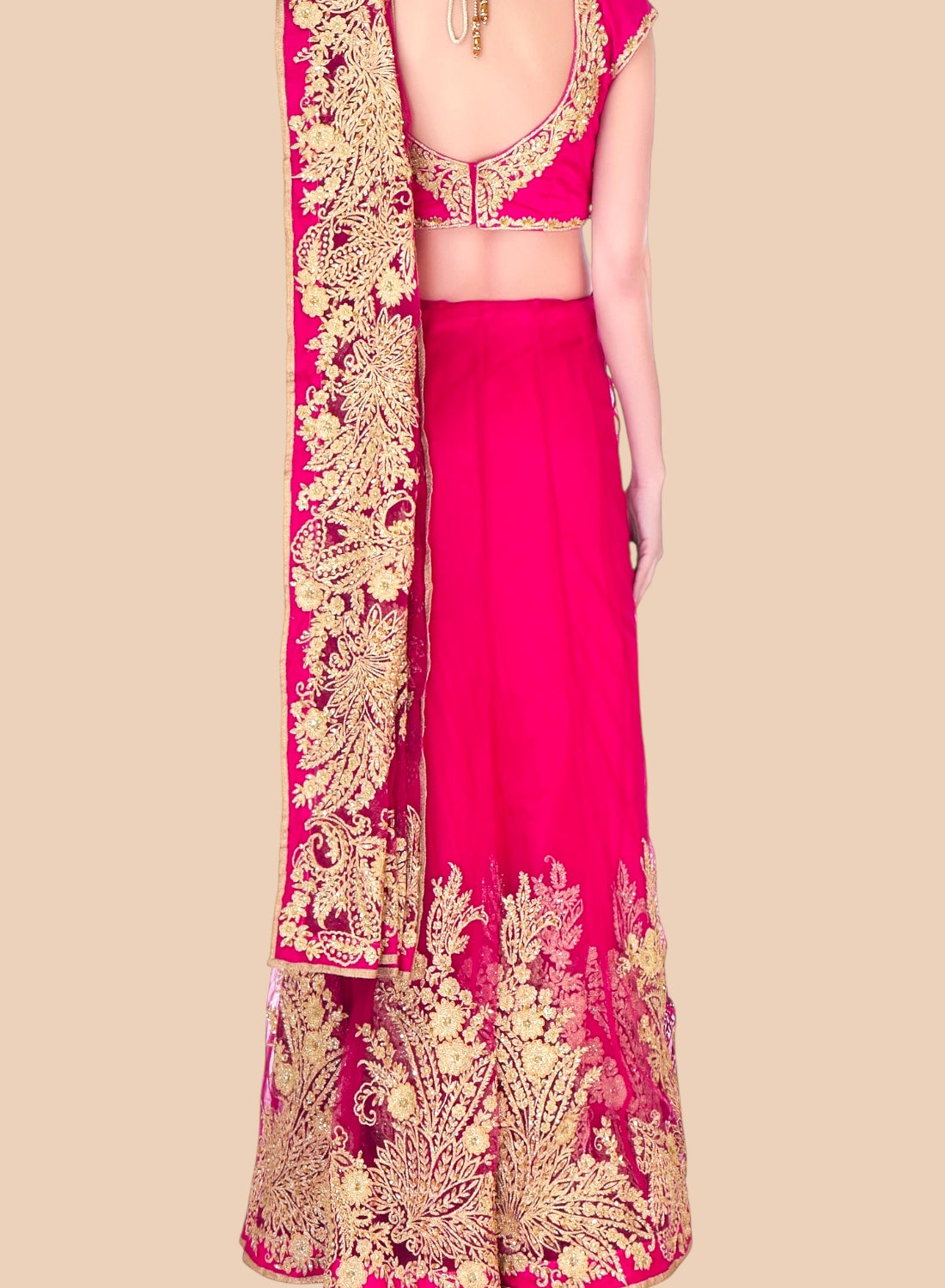 Pink traditional outfit with gold embroidery on a beige background