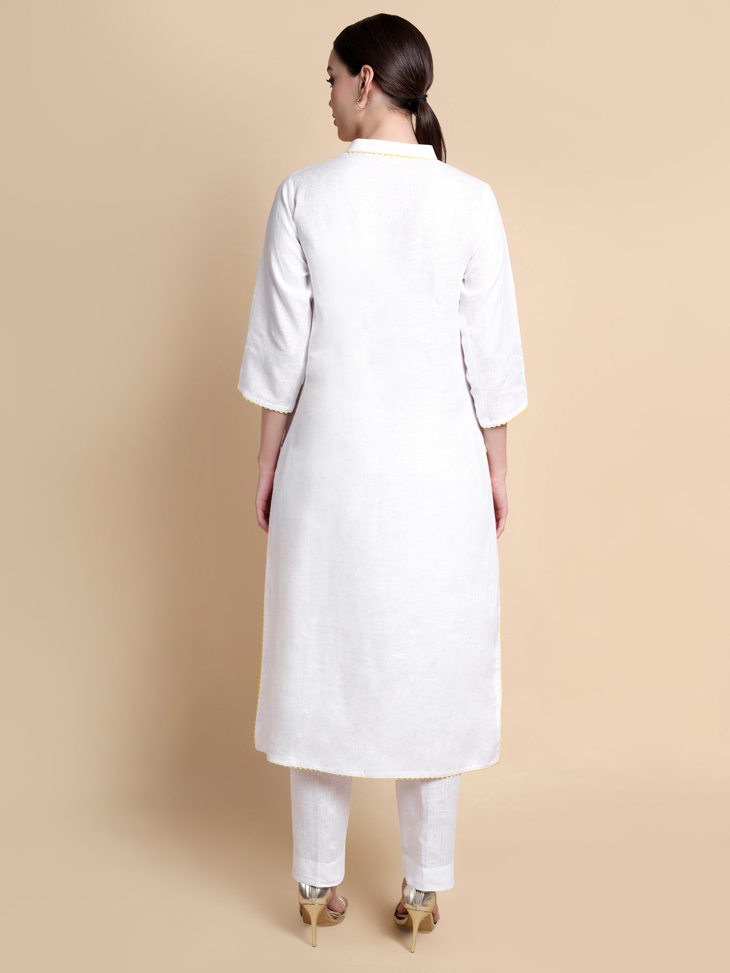 Woman wearing a white kurta with a beige background