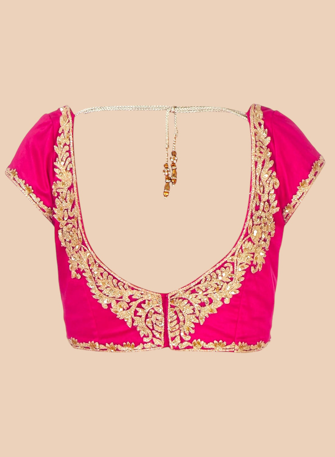 Pink blouse with gold embroidery on a beige background