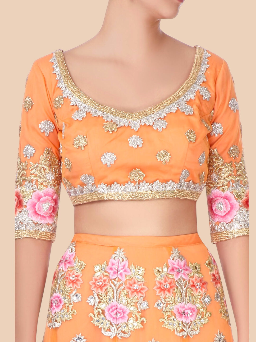 Orange embroidered blouse with floral patterns on a beige background