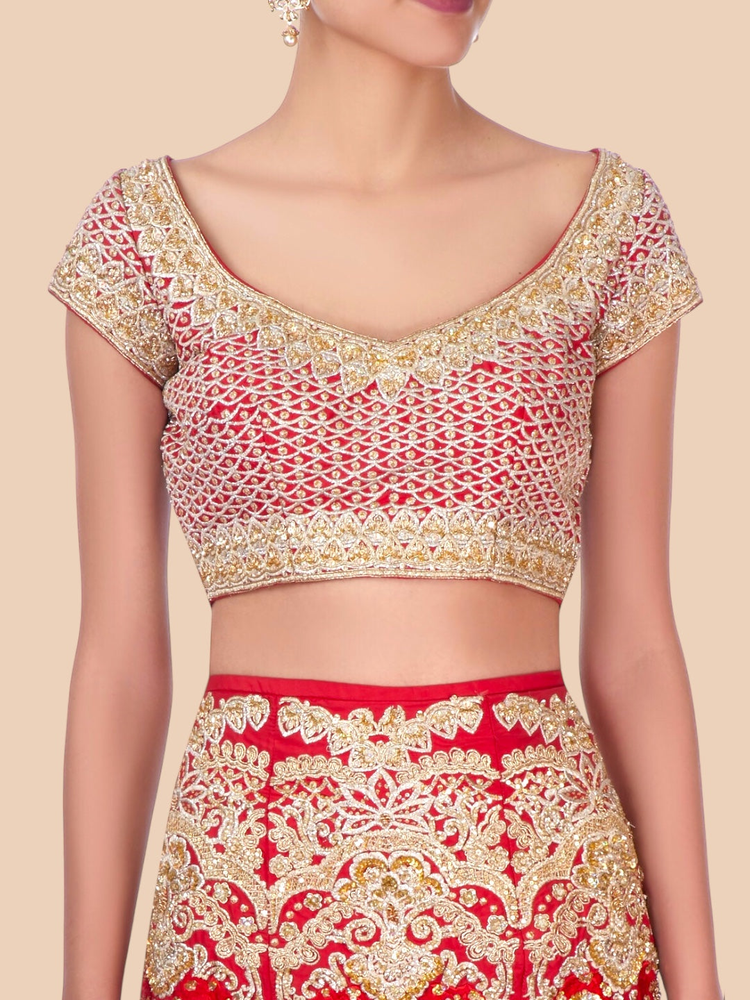 Red and gold embroidered traditional outfit on a beige background