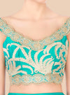 Teal top with gold embroidery on a beige background