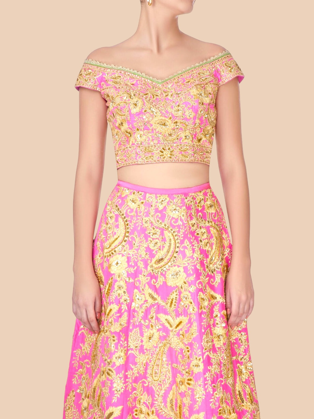 Woman wearing a pink and gold patterned outfit on a beige background