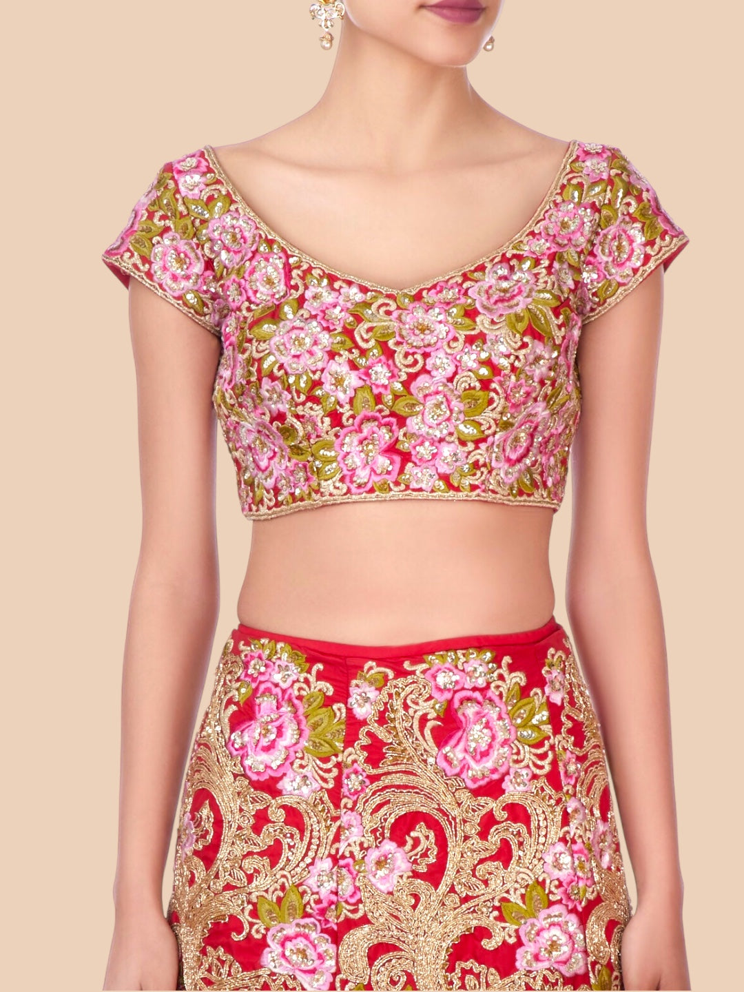Traditional outfit with floral blouse and red skirt on a beige background