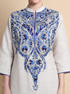 White kurta with blue intricate embroidery on a beige background
