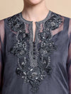 Dark gray sleeveless top with intricate floral embroidery on a beige background