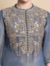 Blue embroidered garment with gold details on a beige background