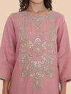 Pink embroidered kurta worn by a person on a beige background
