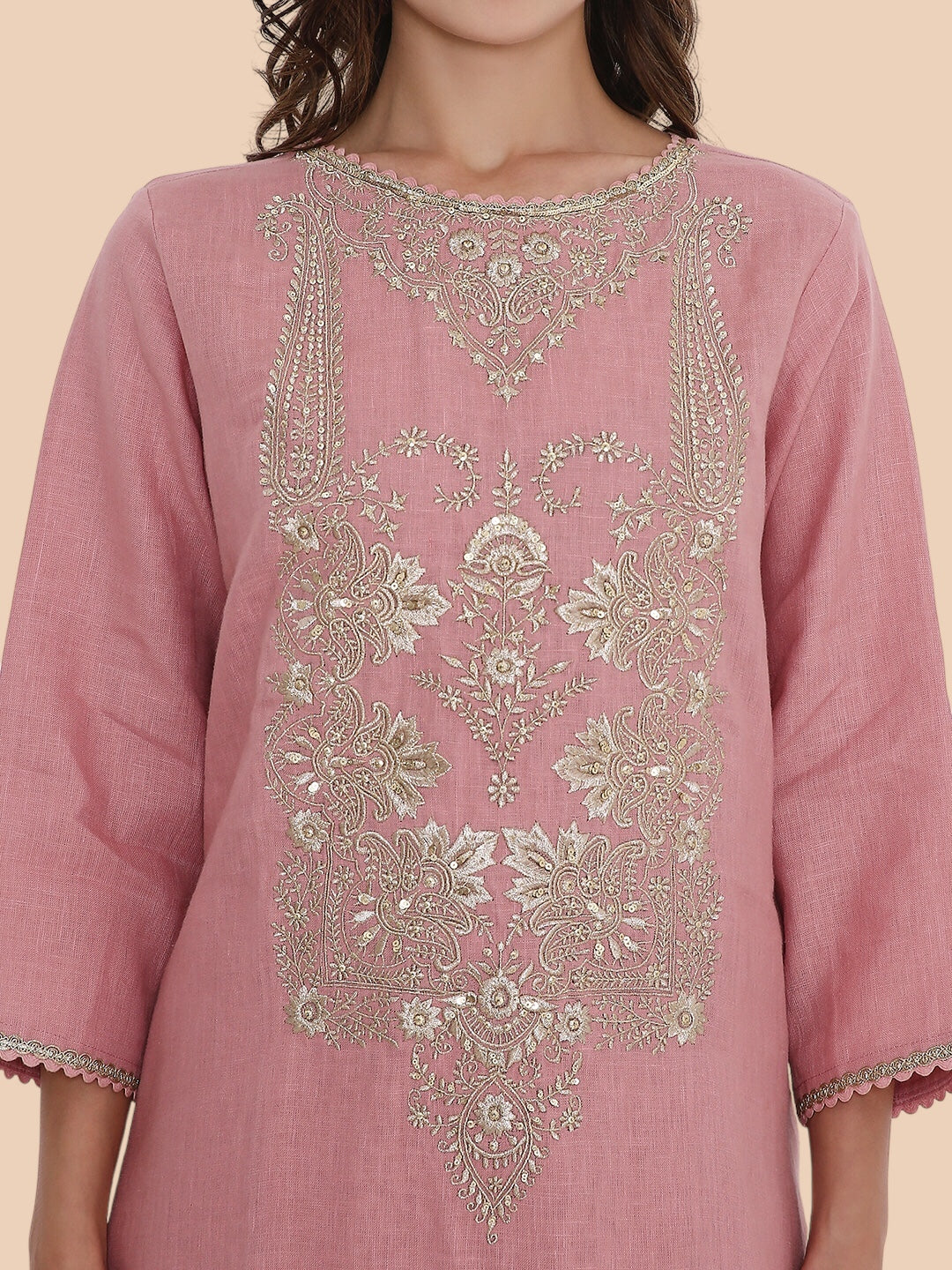 Pink embroidered kurta worn by a person on a beige background