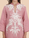 Pink kurta with white floral embroidery on a beige background