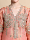 Close-up of a pink embroidered garment with intricate silver detailing.