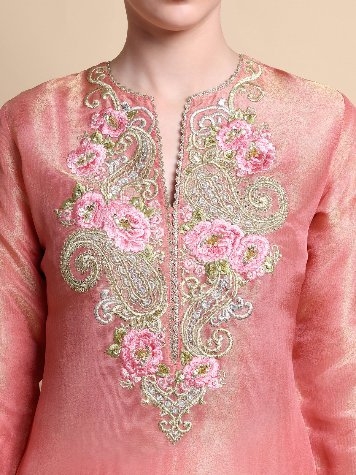 Pink embroidered garment with floral and paisley patterns on a beige background