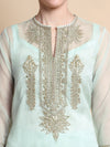 Light blue embroidered top with intricate gold patterns on a beige background