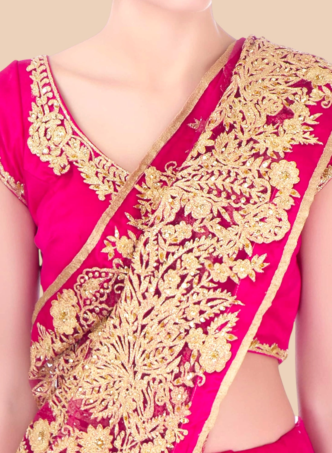 Pink saree with gold embroidery on a plain background