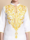 White top with intricate gold embroidery on a beige background