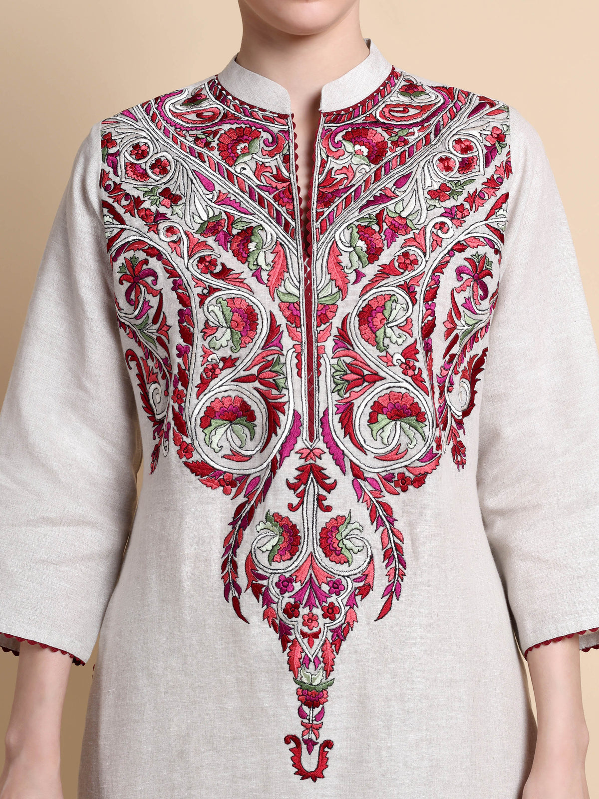 Embroidered kurta with intricate patterns on a beige background