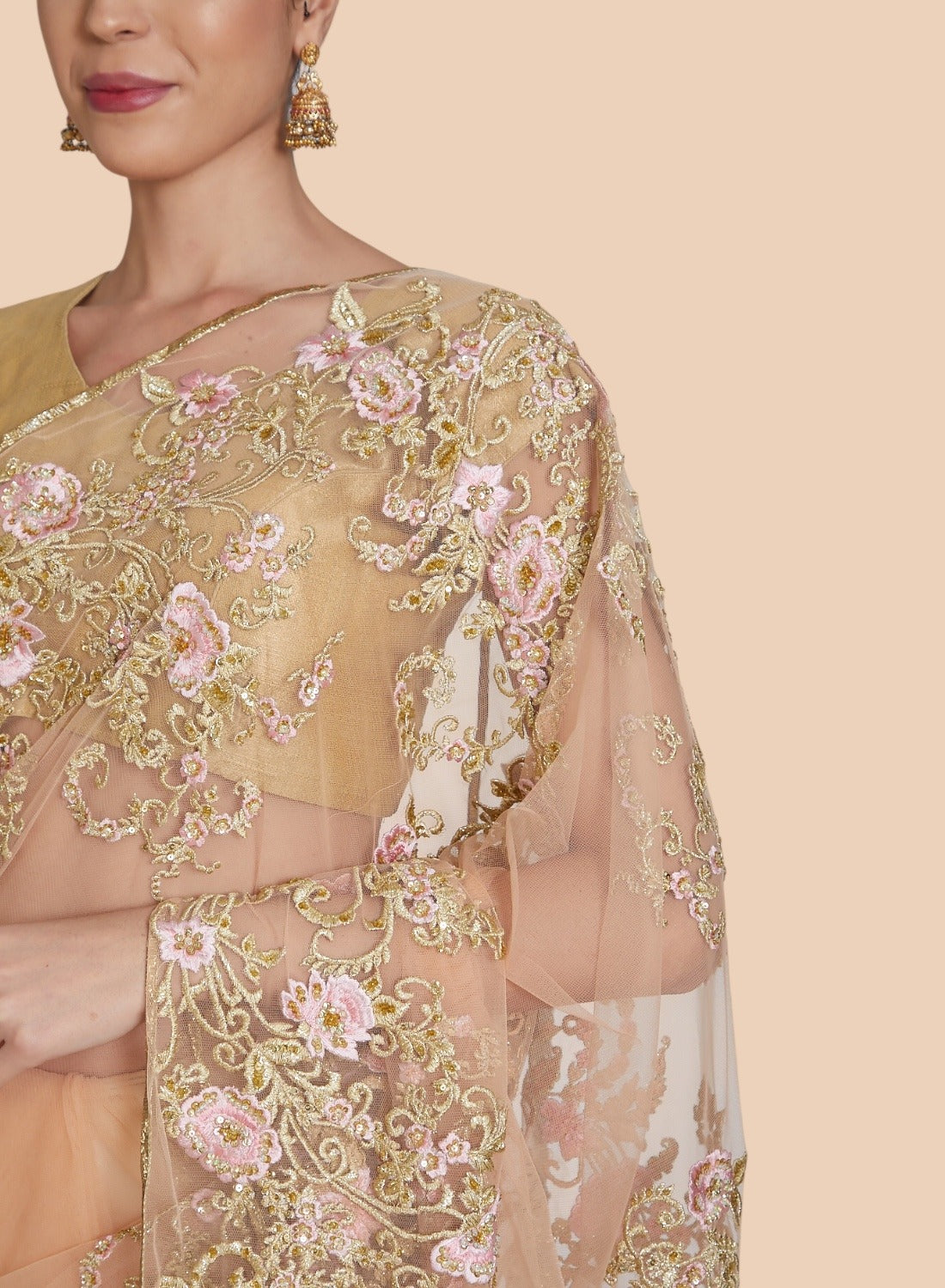 Close-up of gold resham floral border embroidery on peach sari