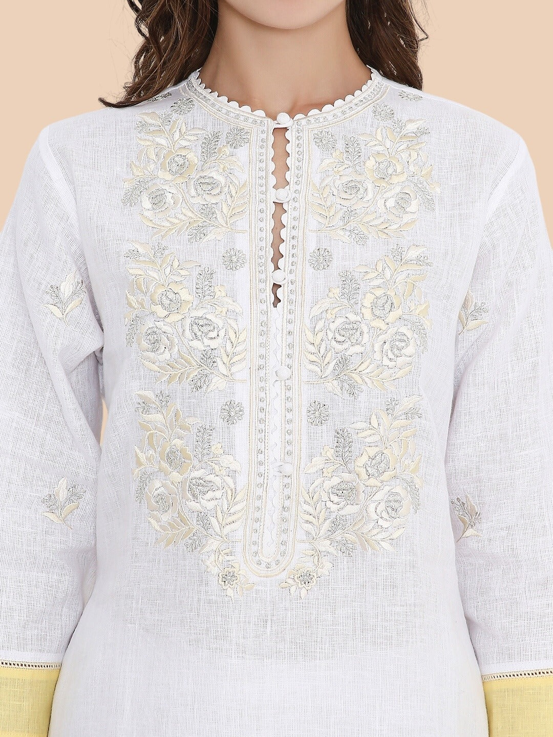 Close-up of ivory resham and zari embroidery on neckline and sleeve of kurta
