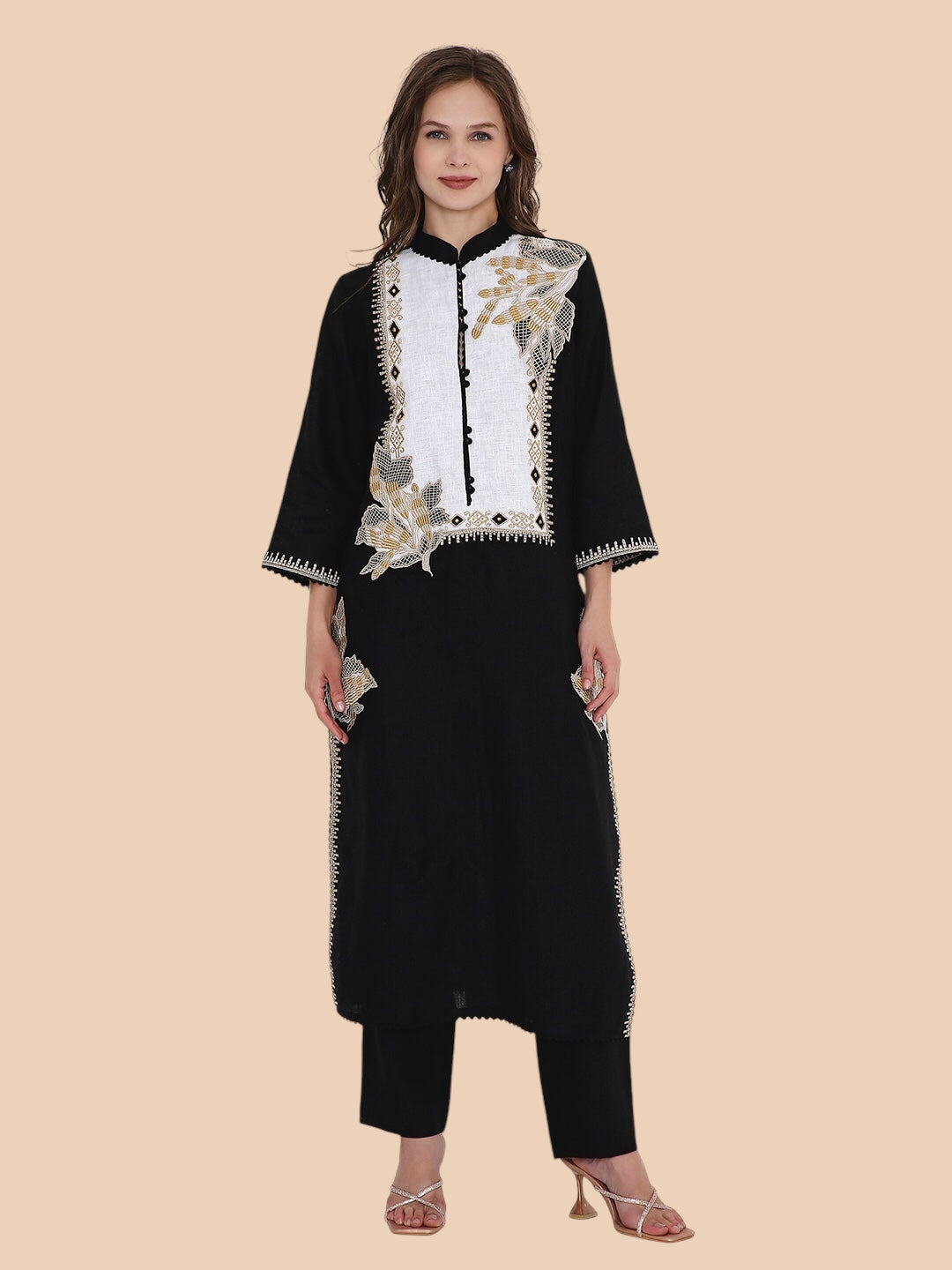 Woman wearing a black outfit with floral embroidery on a beige background