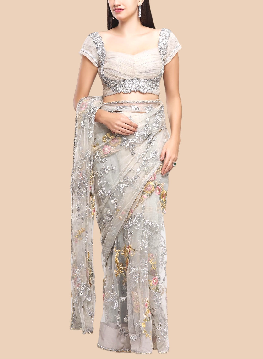Woman wearing a floral saree with a beige background