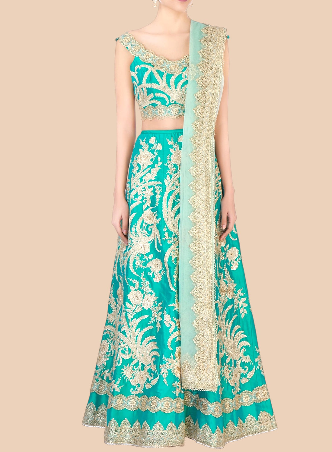 Teal and gold embroidered traditional outfit on a beige background