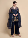 Woman wearing a navy blue traditional outfit with gold embroidery on a beige background