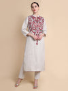 Woman wearing a white kurta with red and gold embroidery on a beige background