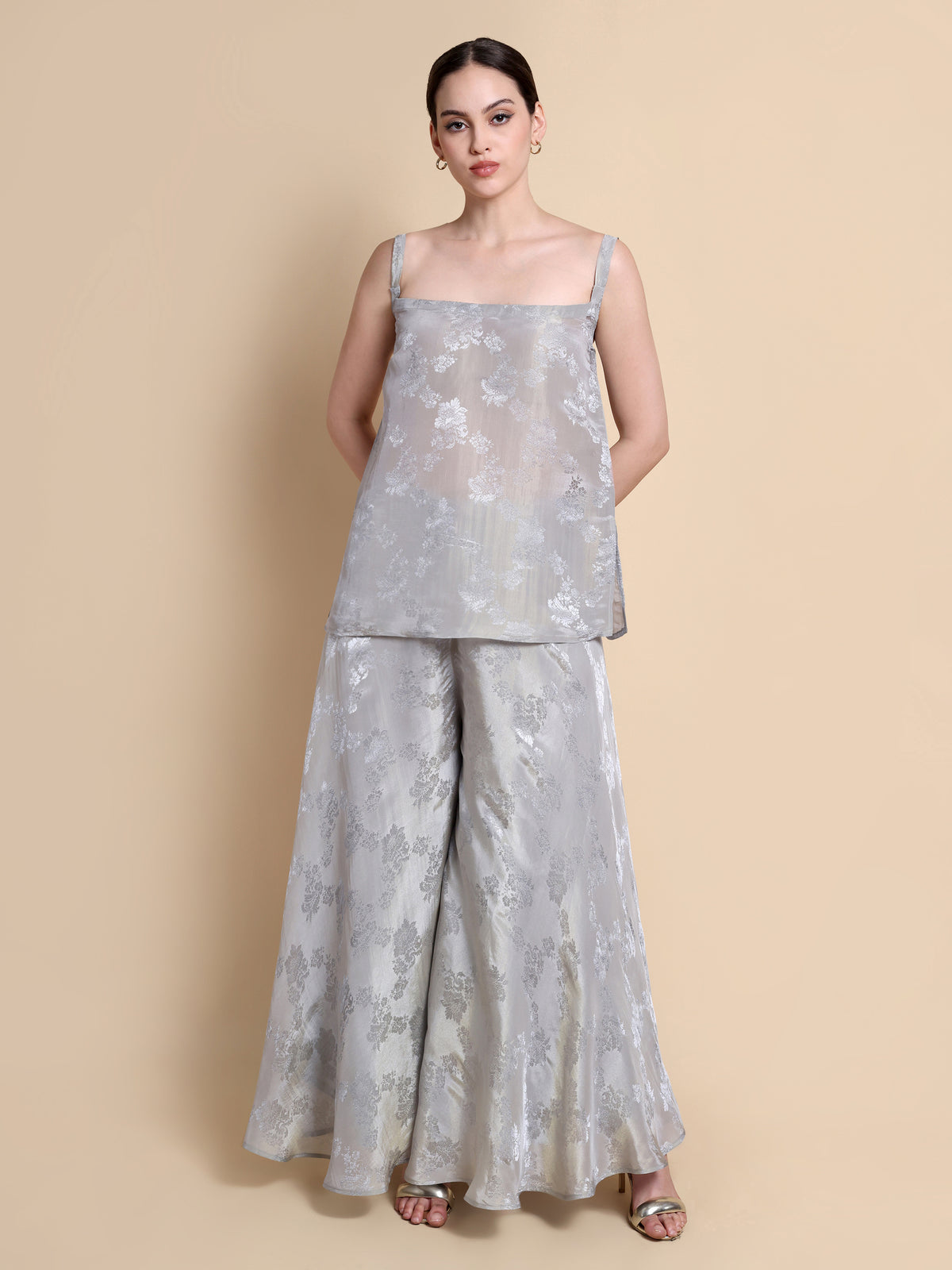 Woman wearing a light gray floral outfit on a beige background