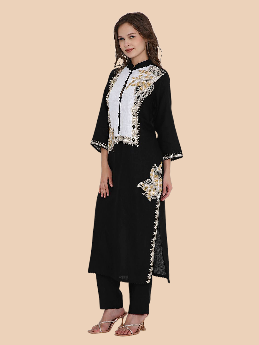 Woman wearing a black and white embroidered outfit on a beige background