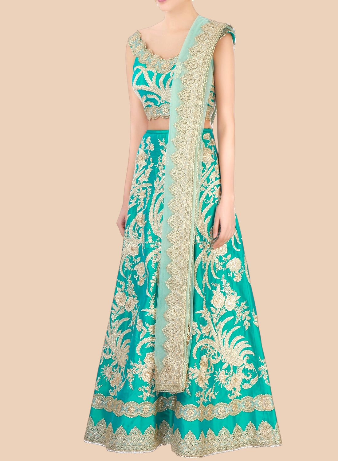 Teal embroidered traditional outfit with gold details on a beige background