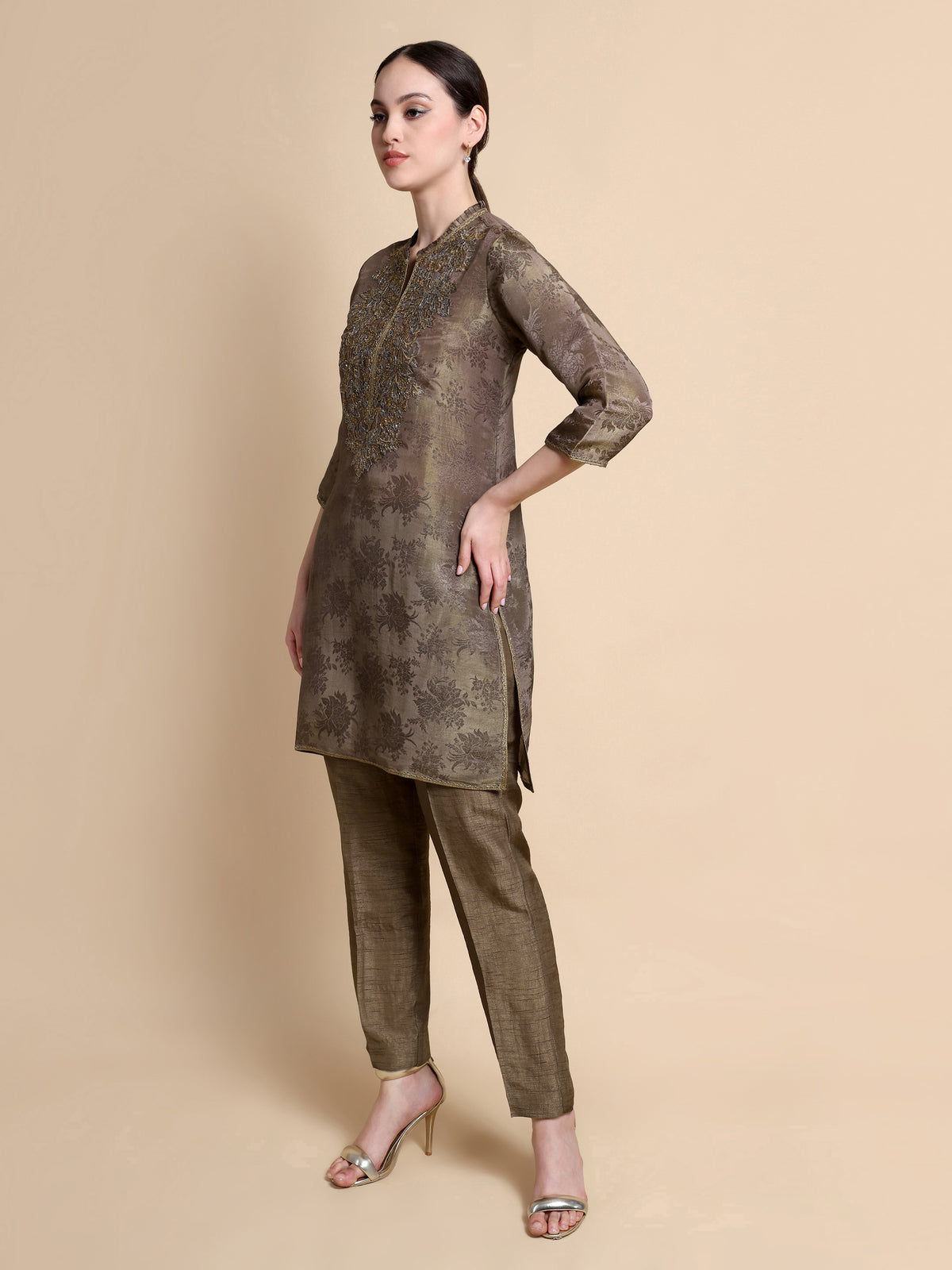 Woman wearing a brown traditional outfit with a beige background